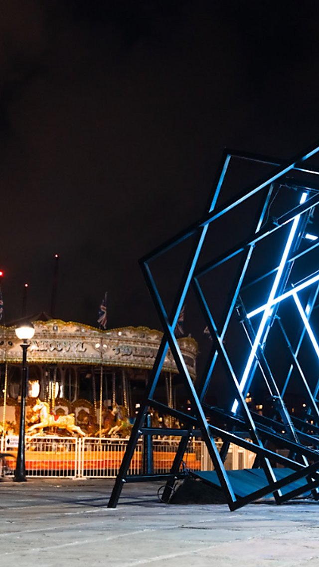 An art installation made of diffrent squares in a line lit up blue.