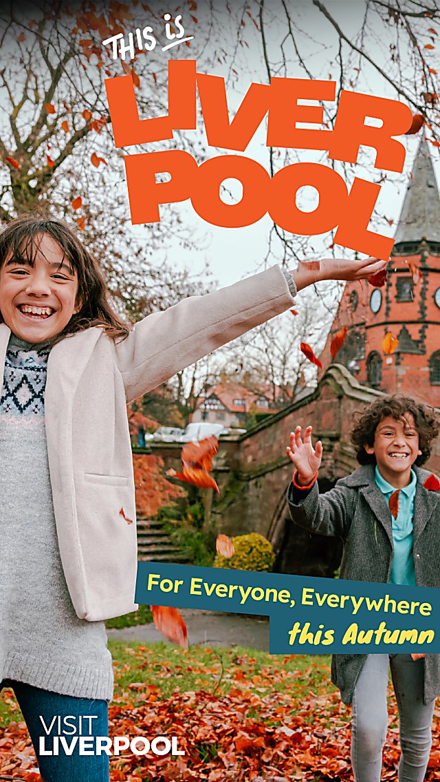 Two kids playing in leaves with a large brick building and trees beind them. The text says This is Liverpool in orange letter.