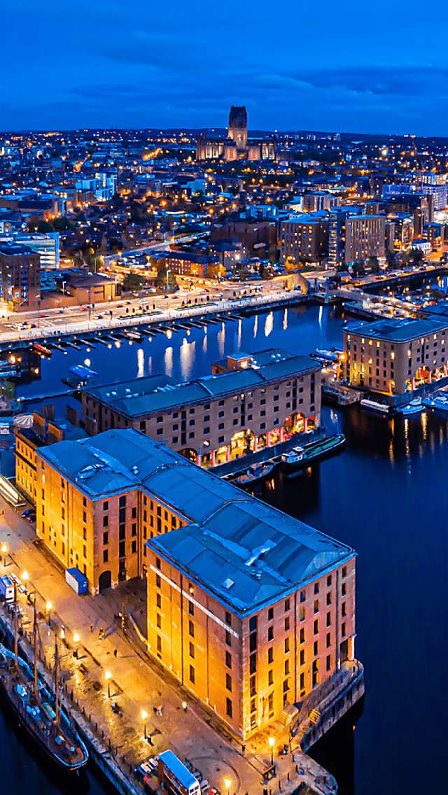 A drone shot of Royal Albert Docks in Liverpool with the wheel of Liverpool in the distance.