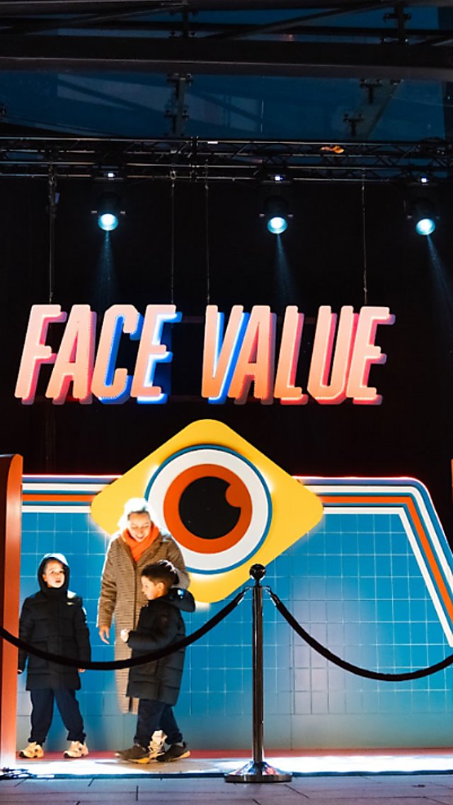 A red carpet style artwork that has 'Face Value' writting in big letters with an illustration of an eye under it.