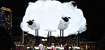 A large light installation in the shape of a cloud with sheep on it.