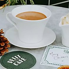 Petit cafe table with a mug of hot chocolate and cup of whipped cream.