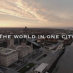 A drone shot of Liverpool's Pier Head at sunrise with the words The World in One City over the top.