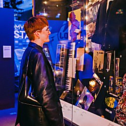 A girl looks inside a cabinet in the British Music Experience