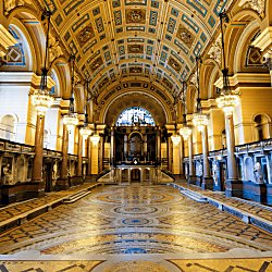 Inside St George's Hall with an intricate tiled flooring and ceiling.
