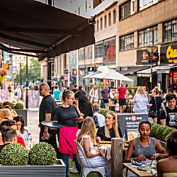 People sitting outside on parklets and