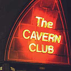 A neon red sign that reads 'Cavern Club' lit up at night time.