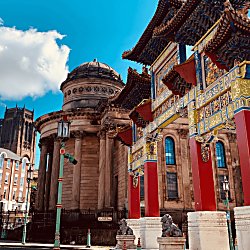 A large Chinatown Arch alongside a Grecian style building.