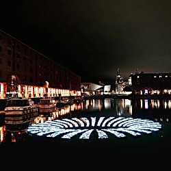 An image of Illusion Hole situated in the Royal Albert Dock at night with the lights shining brightly.