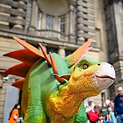 A green dinosaur with orange scales and a yellow neck.