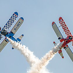 A red and a blue plane flying next to eachother.