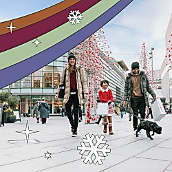 A family of three with two adults and a child with a dog in a shopping centre. There is a rainbow of colours added over the top of the image.
