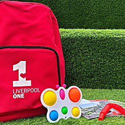 A red bag with Liverpool ONE logo on it, along with fidget toys and ear defenders.