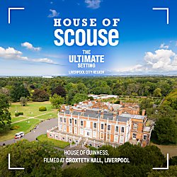a drone shot of Croxteth Hall, a stately home surrounded by green gardens and trees.