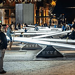 Children playing on the installation with bright lights shining in a dark night.