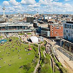 A drone shot of Liverpool ONE shopping centre with a large expanse of grass.