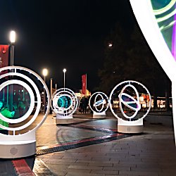 Light installations in circles that spin around with lights in the middle of it.