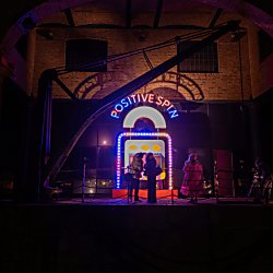 A light installation that says 'Positive Spin' with several different colours in red, yellow, blue and green.