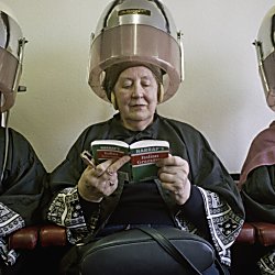 3 women having their hair blowdried by a machine in the hairdressers.