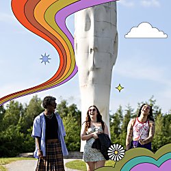 Three people smiling and walking with The Dream in the background.