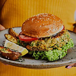 A vegan burger on a plate with potato wedges