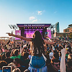 A girl on someones shoulders at a festival on Liverpool Waterfront on a sunny day