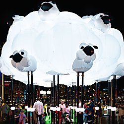 A large light installation in the shape of a cloud with sheep on it.