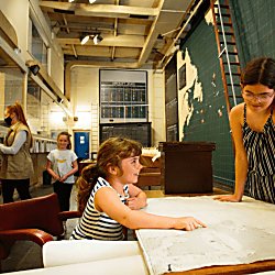 Two young children looking over a map in Western Approaches.
