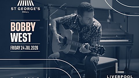 Promotional graphic for a Bobby West performance at St George’s Hall. The design features a monochrome blue-toned photograph of a musician seated and playing an acoustic guitar, with a piano visible in the background. White and pale pink text on the left reads “Bobby West” and “Friday 24 Jul 2026.” The St George’s Hall logo appears in the upper left, the website liverpoolcityhalls.co.uk is displayed along the bottom left, and the Liverpool City Halls logo is positioned in the lower right corner. Decorative curved line elements frame the design.