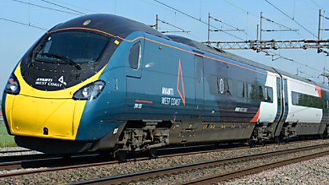 An Avanti West Coast train on the tracks, with grass on the bottom right of the image.
