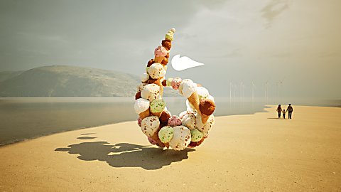 A 6 icon made from ice cream on a beach with a family walking