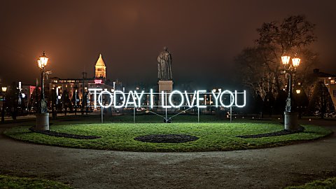 A light art installation that says Today I Love You in a park.