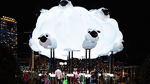 A large light installation in the shape of a cloud with sheep on it.
