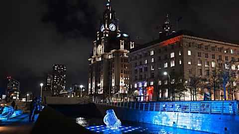 An artwork of a hand that looks like it is floating on water with lights around it.