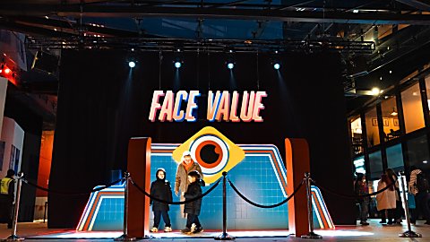 A red carpet style artwork that has 'Face Value' writting in big letters with an illustration of an eye under it.