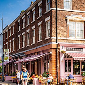 Two people on a Voi Scooter in the Georgian Quarter on a sunny day