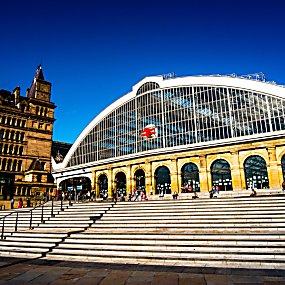 Liverpool Lime Street train station exterior with a bright blue sky.