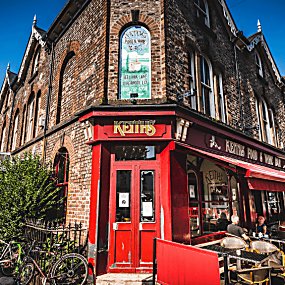 An exterior shot of a cafe with an old Victorian Style shop front painted red