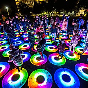 Colourful rings on the floor that are lit up with people walking on them