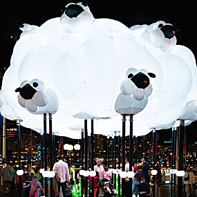 A large light installation in the shape of a cloud with sheep on it.