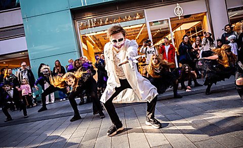 People dressed in halloween fancy dress outfits dancing outdoors at Liverpool ONE