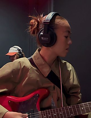A gif of a boy and girl playing a guitar and drums