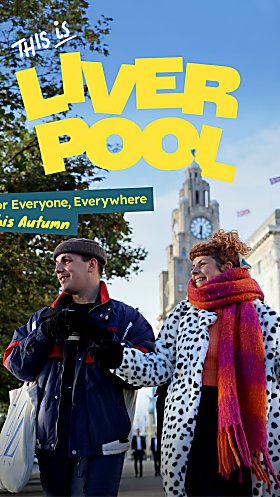 Two people walking through Liverpool city centre in autumn, with the Royal Liver Building in the background and promotional text reading ‘This is Liverpool’.