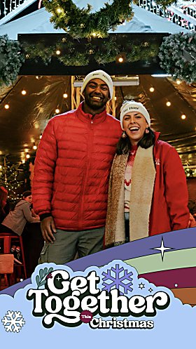 Two people stood at a Christmas bar with decorations beind them. There is a logo that says Get Together this Christmas.