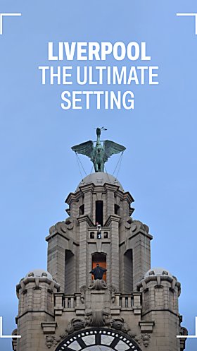The Batman standing on top of the Royal Liver Building, above the clock. The sky is blue and there's white text which says 'Liverpool The Ultimate Setting'.