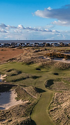 A drone shot of the course at Royal Liverpool in Hoylake. There are bunkers and grassy hills.