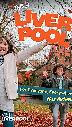 Two children playing in leaves with a large brick building and trees behind them. The text on the image says 'This is Liverpool' in orange writing. and For everyone, Everywhere, this Autumn' in yellow on a green background.