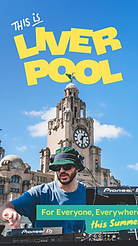 A DJ on a roof with the Royal Liver Building in the background. The sky is blue and it says 'This is Liverpool' in yelow text.