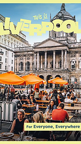 Outside Liverpool Town Hall with people sitting at tables eating food. There are orange umbrellas over some of the tables.