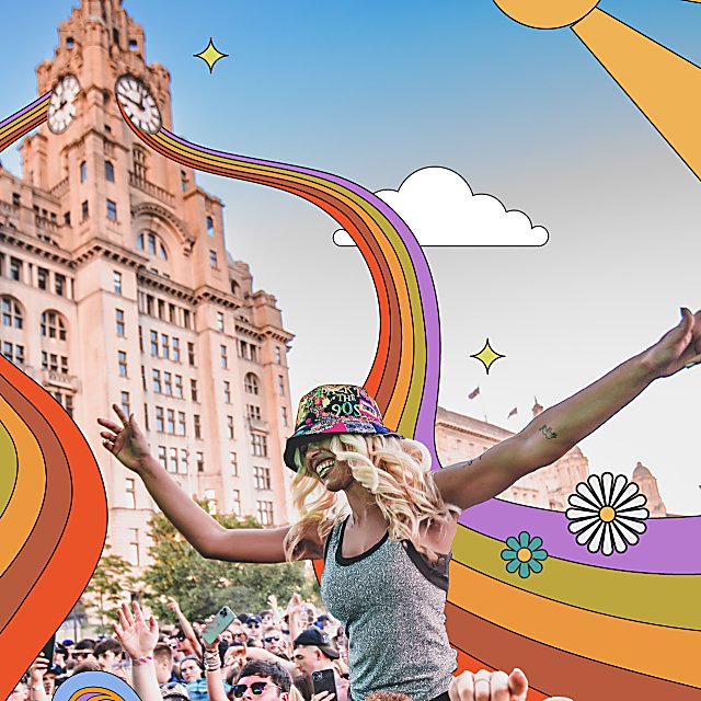 A person on someone's shoulders at a festival with the Liver Building in the background.